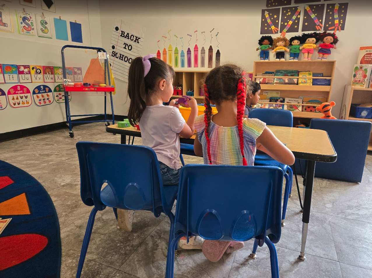 Preschoolers working at tables in a colorful classroom