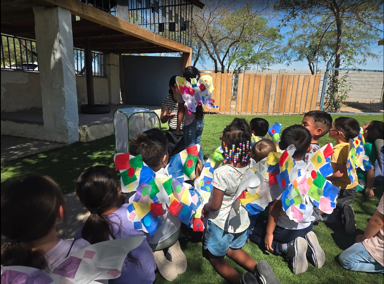 Children wearing colorful handmade butterfly wings outside