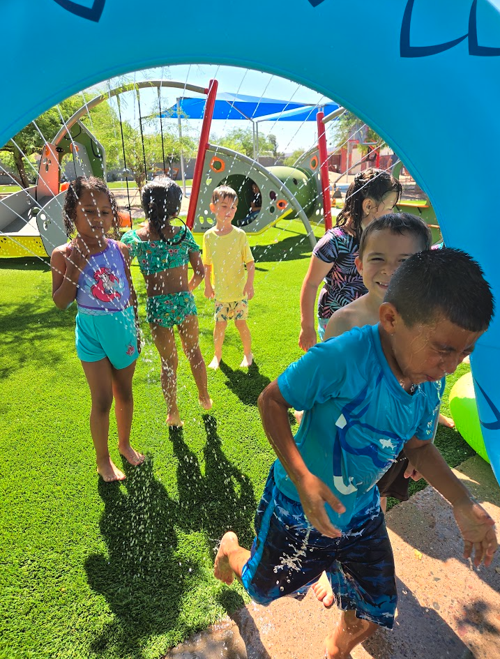 Children running and playing through water at the outdoor splash pad