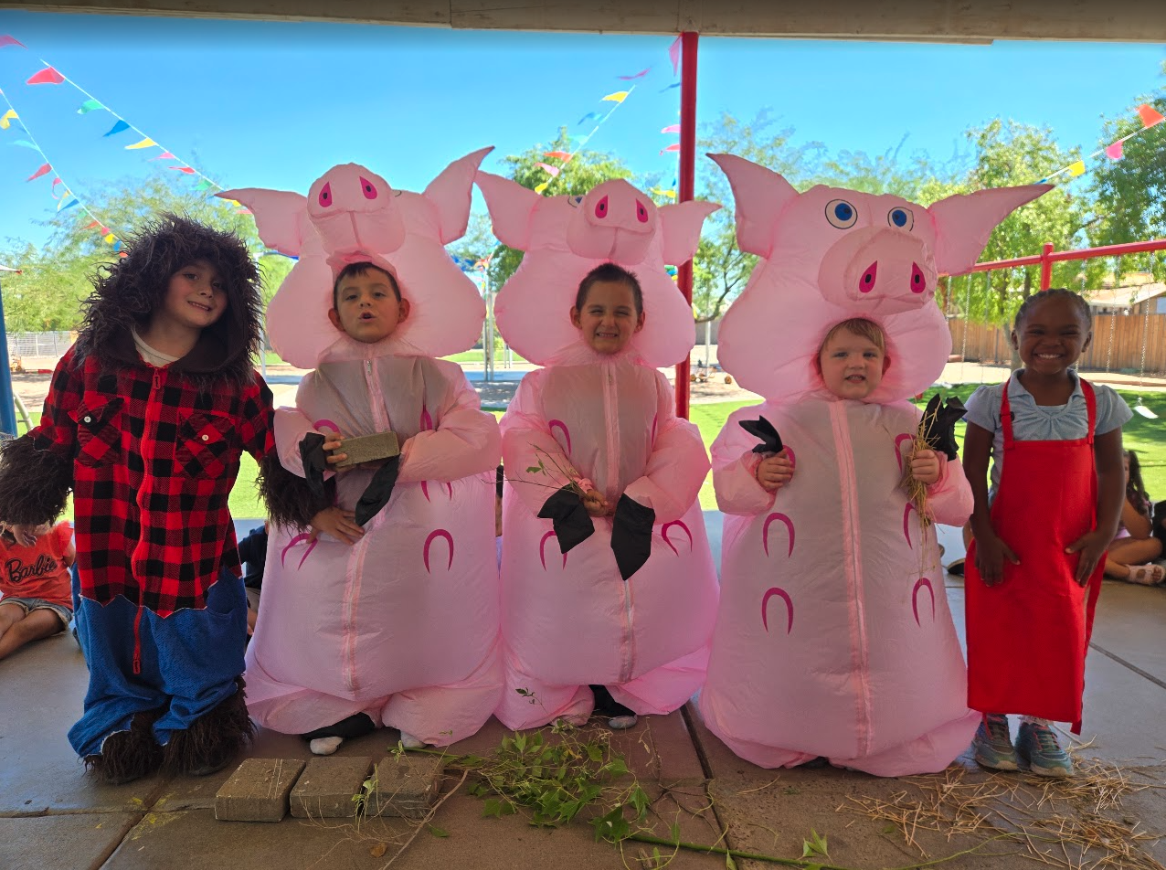 Children dressed as the Three Little Pigs and the wolf in a story reenactment