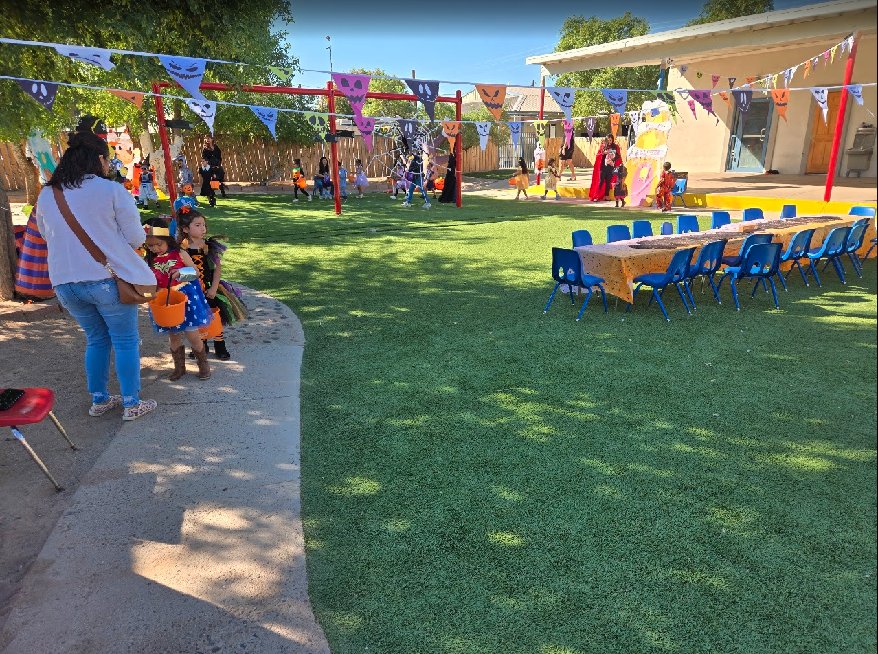 Costumed children at an outdoor Halloween celebration on the playground